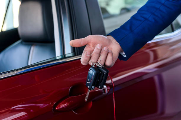 istock Male hand with keys against new red car 1180638420