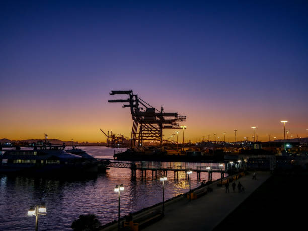 フェリーとクレーンで日没時にカリフォルニア州オークランドの海港 - port of oakland ストックフォトと画像