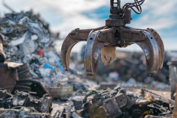 Close-up view on mechanical arm claw of crane at landfill. stock photo