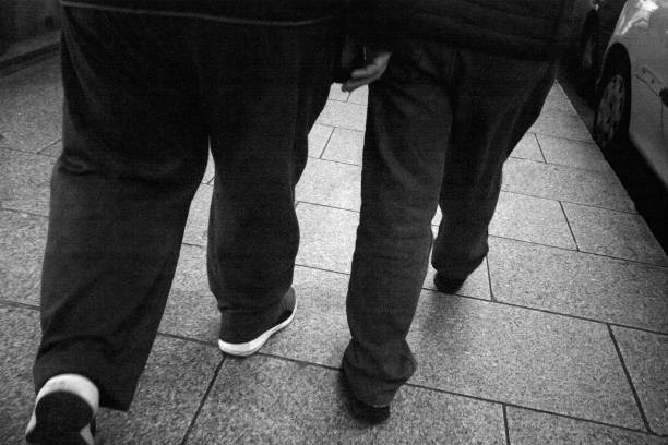istock Two men walking on street paving stone floor. 1180649682