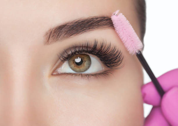 Beautiful Woman with long eyelashes in a beauty salon. Eyelash extension procedure. Lashes close up. Cosmetology concept Beautiful Woman with long eyelashes in a beauty salon. Eyelash extension procedure. Lashes close up. Cosmetology concept Eyelash Extensions stock pictures, royalty-free photos & images