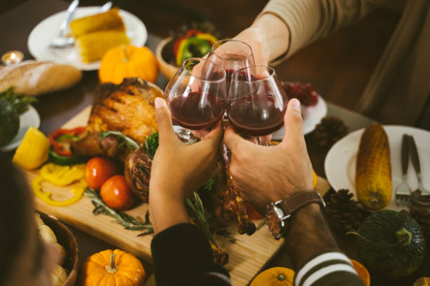 groupe de personnes appréciant le dîner ensemble. dîner wine cheers party thanksgiving concept - thanksgiving cheerful happiness gratitude photos et images de collection