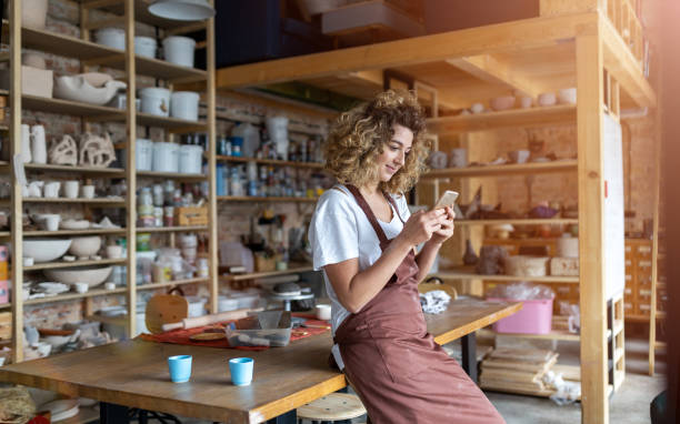 kobieta garncarz ze smartfonem w studio sztuki - sculptor ceramics art potter zdjęcia i obrazy z banku zdjęć