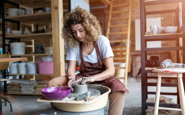 kobieta wykonująca ceramiczną pracę z kołem garncarskim - koło garncarskie zdjęcia i obrazy z banku zdjęć