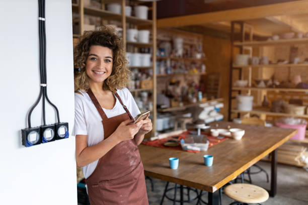 kobieta garncarz ze smartfonem w studio sztuki - sculptor ceramics art potter zdjęcia i obrazy z banku zdjęć