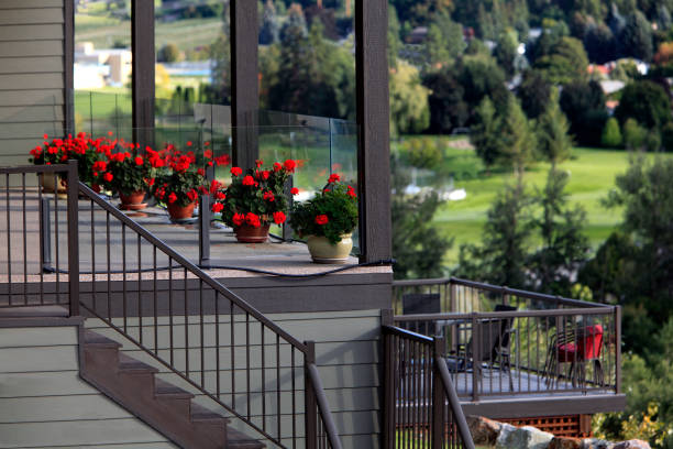 Vernon British Columbia,Canada - September 20,2019:  Residential stairway going up and down to lower and upper deck.  Patio furniture on lower deck. Pots of  Red Geraniums on upper deck. Acrylic glass panels on upper deck.