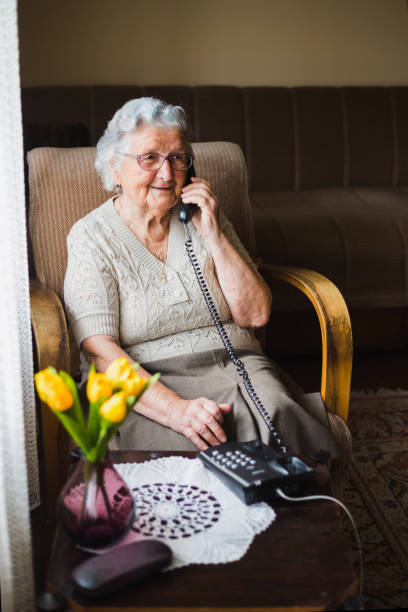 istock An old woman uses a phone in a nursing home. 1180667455