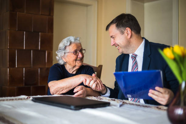 Happy senior woman with her lawyer.\nTwo generations shaking hands.\nOld woman is smiling very satisfied.