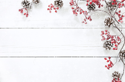 Christmas berry garland border on an old white wood background