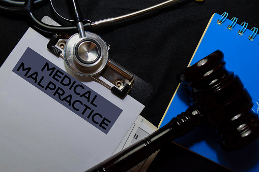 Medical Malpractice Document form and Black Judges gavel on office desk. Law concept
