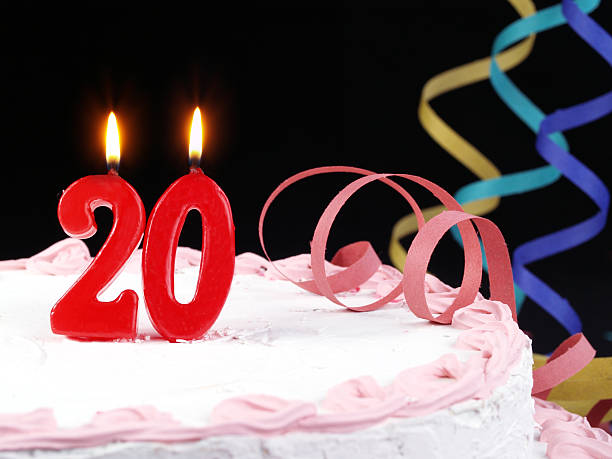 A pink cake with red number twenty candles stock photo