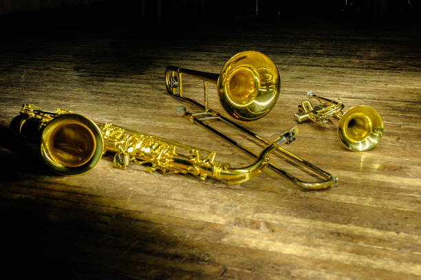 istock Brass and wind instruments - saxophone, trombone, trumpet on stage with backlight 1180675604