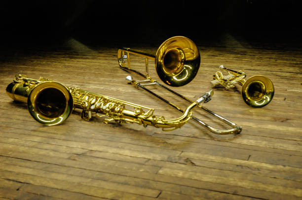 istock Yellow brass and wind instruments - saxophone, trombone, trumpet on stage with backlight 1180675694