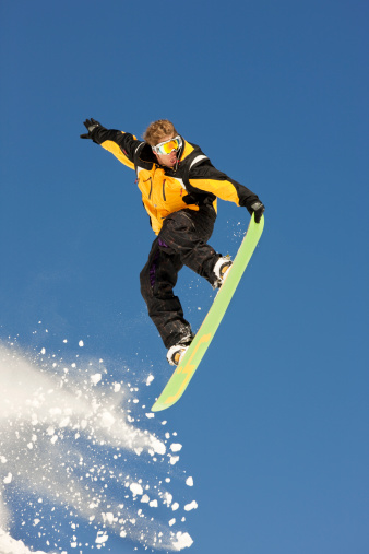 Snowboarder having fun making a jump in the air.