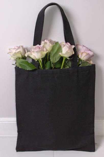 istock Black cotton tote bag with light violet roses inside. Styled photography 1180679903
