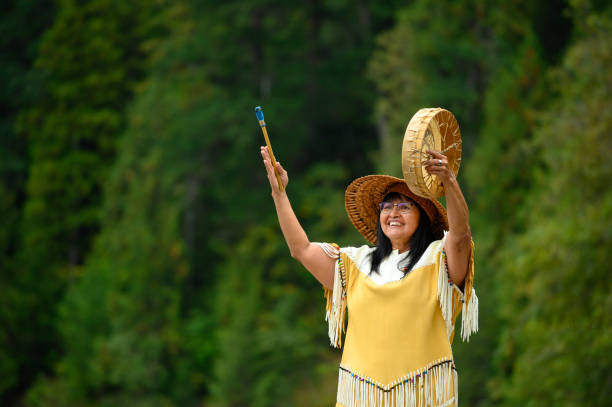 First Nations woman performing a welcome song First Nations woman performing a traditional welcome song. Traditional Canadian culture. Native American culture. canadian culture stock pictures, royalty-free photos & images