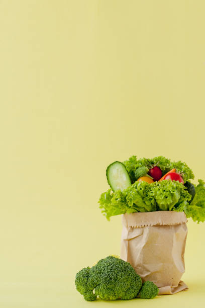 istock Shopping bag with groceries on yellow background 1180684562