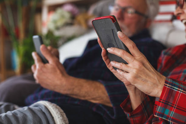 istock Close up of senior couple using mobile phones 1180686864