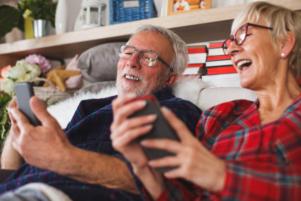 istock Cheerful senior couple using mobile phones in bed 1180686878