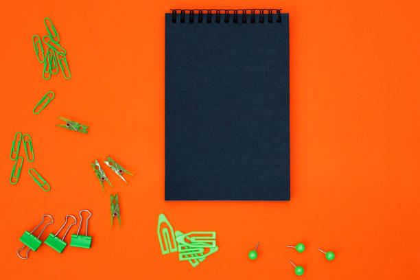 istock Educational composition, stationery. Green stationery and black notebook on a black background. Flat lay, top view, copy space. 1180688424