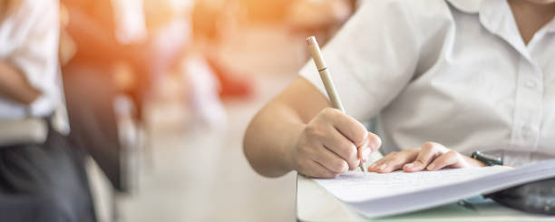istock Exam at school with student's taking educational admission test in class, thinking hard, writing answer in university classroom, education and world literacy day concept 1180689032