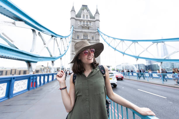 istock Woman with hat, backpack and sunglasses walking in London 1180689038
