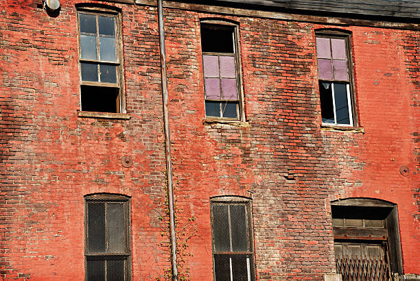 istock Urban decay red brick abandoned building with broken windows 118069313