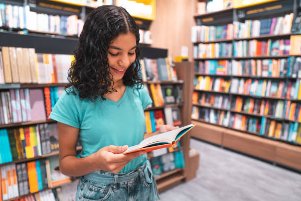 livre de lecture d'étudiant dans la bibliothèque - porter sur la tête photos et images de collection