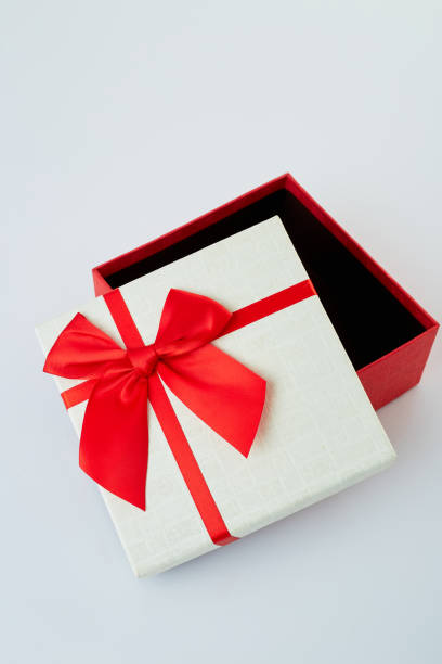 istock White gift box with red ribbon bow on white background 1180704889