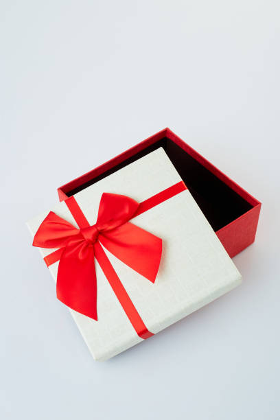 istock White gift box with red ribbon bow on white background 1180704914