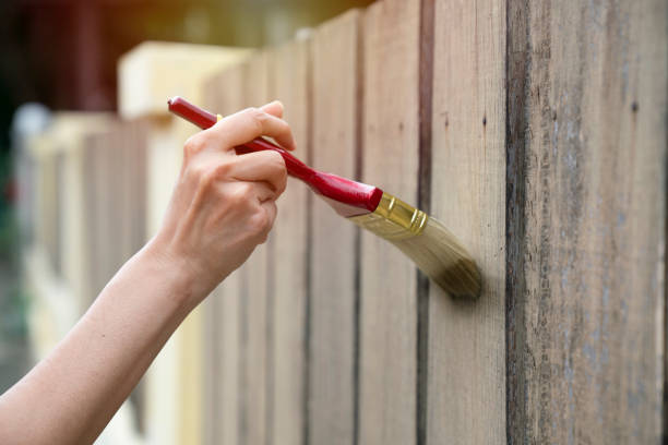 istock Applying protective varnish on a wooden fence, diy concept 1180708134