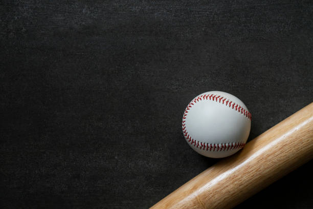 istock baseball and baseball bat on black table background, close up 1180708206