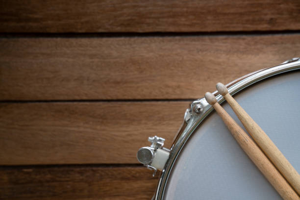 istock close up drum stick and drum on wooden table background, top view, music concept 1180708236