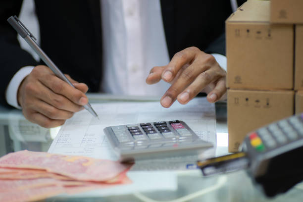 istock closeup.business man using a calculator at the workplace,Business man using calculator working at office with reports document financial. 1180709648