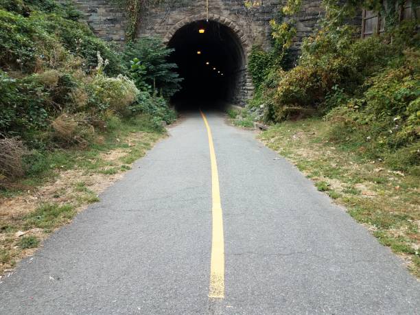istock black asphalt path or trail and dark tunnel 1180710580