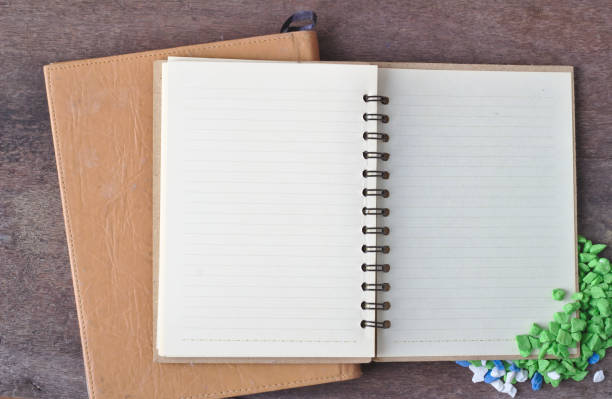 Notebook opens Inside blank text background notepad brown cover Laid on the table, old wooden floor The side of the stone is green and white.