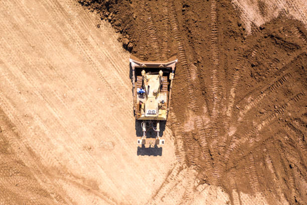 istock Bulldozer pushing large amount of fresh soil 1180717489