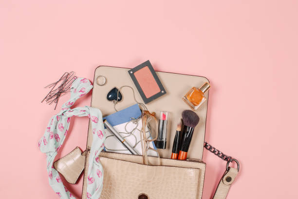 istock Top view of Women bag and lady stuff with copyspace on pink background 1180720021