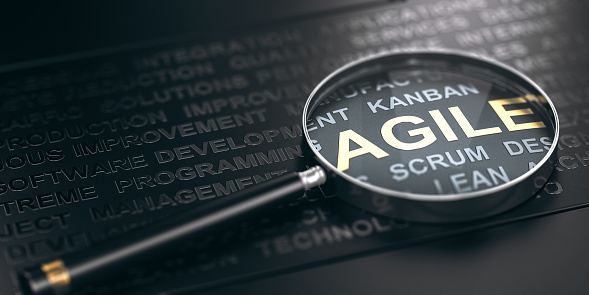 3D illustration of many words over black background and a magnifying glass with focus on the word agile.