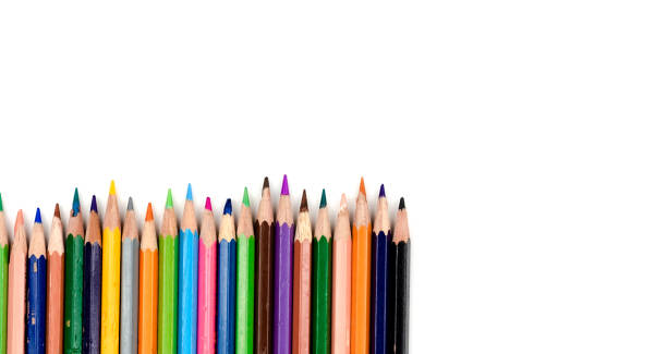 istock Old colored pencils. Some old colored pencils lined up on a white table 1180723137