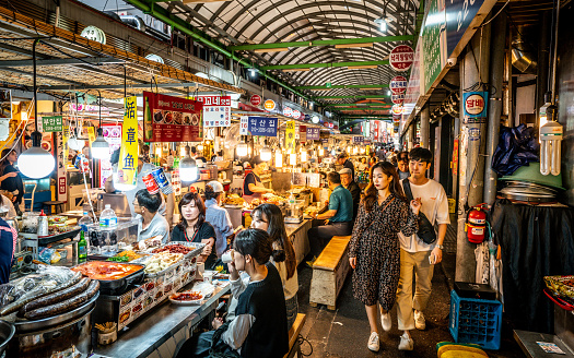 Seoul Korea , 21 September 2019 : View of an alley of the Kwangjang market at night with people eating street food at stalls