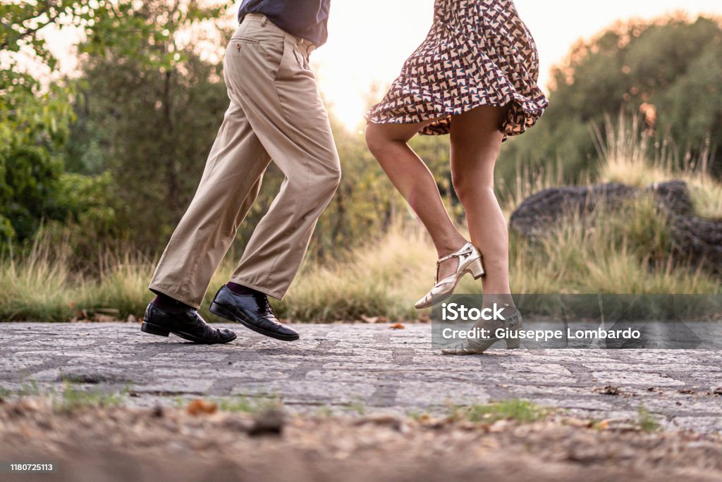 Two adult dancers feet dancing swing music outdoors in the park - unrecognizable people Dancing Stock Photo
