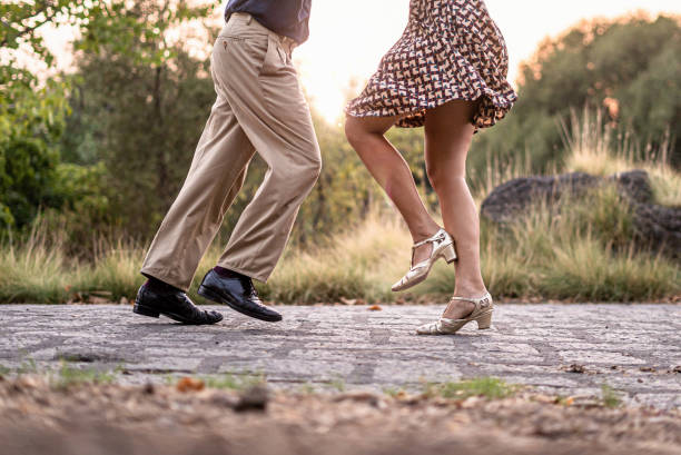 Two adult dancers feet dancing swing music outdoors in the park - unrecognizable people Two adult dancers feet dancing swing music outdoors in the park - unrecognizable people lindy hop stock pictures, royalty-free photos & images