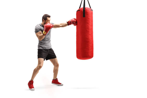istock Man punching a bag with boxing gloves 1180728886