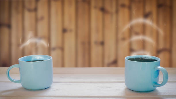 istock Two coffee cup concepts on a wooden table Smoke is volume icon. 1180729003