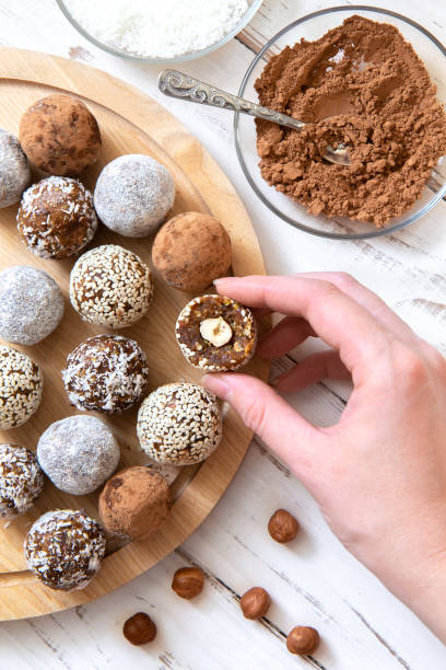 istock Cooking energy balls, hand holds half a ball with a nut 1180731194