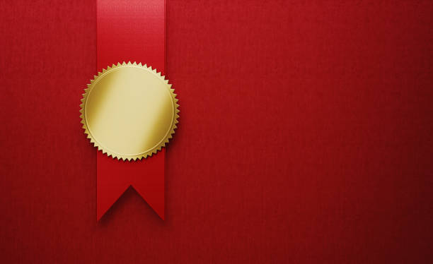 Gold cockade on red award ribbon on red background. Horizontal composition with copy space.