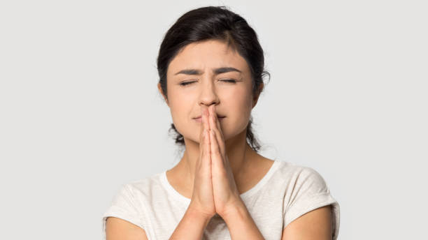 istock Indian girl believer with prayer hands make wish 1180735707