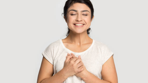 istock Smiling indian girl hold hands at chest feel grateful 1180735731