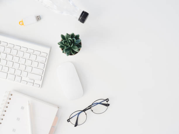 istock top view of office desk table with notebook, plastic plant, digital camera and keyboard on white background, graphic designer, Creative Designer concept. 1180739561